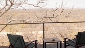 Un espace extérieur abrité, avec deux chaises et une petite table, donnant sur un paysage désolé.