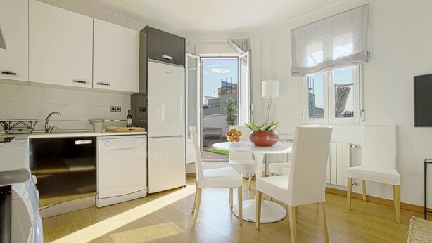 A modern kitchen with white cabinets, a dishwasher, and a dining area with white chairs and a table. - Beautifuly Decorated 2 Bd Apart With Private Terrace, Reina Sofia (Madrid)