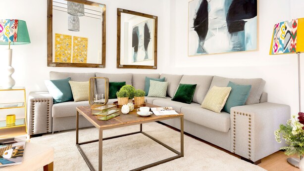 A living room with a sofa, coffee table, and wall art. - Genteel Home San Gregorio (Seville)