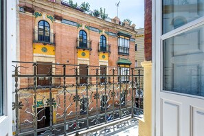 A building with a brick facade, ornate iron balcony railings, and a white door. - Genteel Home San Gregorio (Seville)