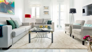 A modern living room with a sofa, armchairs, a coffee table, and a TV. - Genteel Home Encarnacion (Seville)