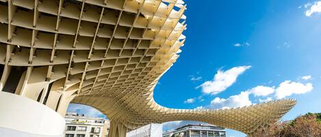 Een moderne architecturale constructie met een rasterachtig patroon en een grote, gebogen overkapping.