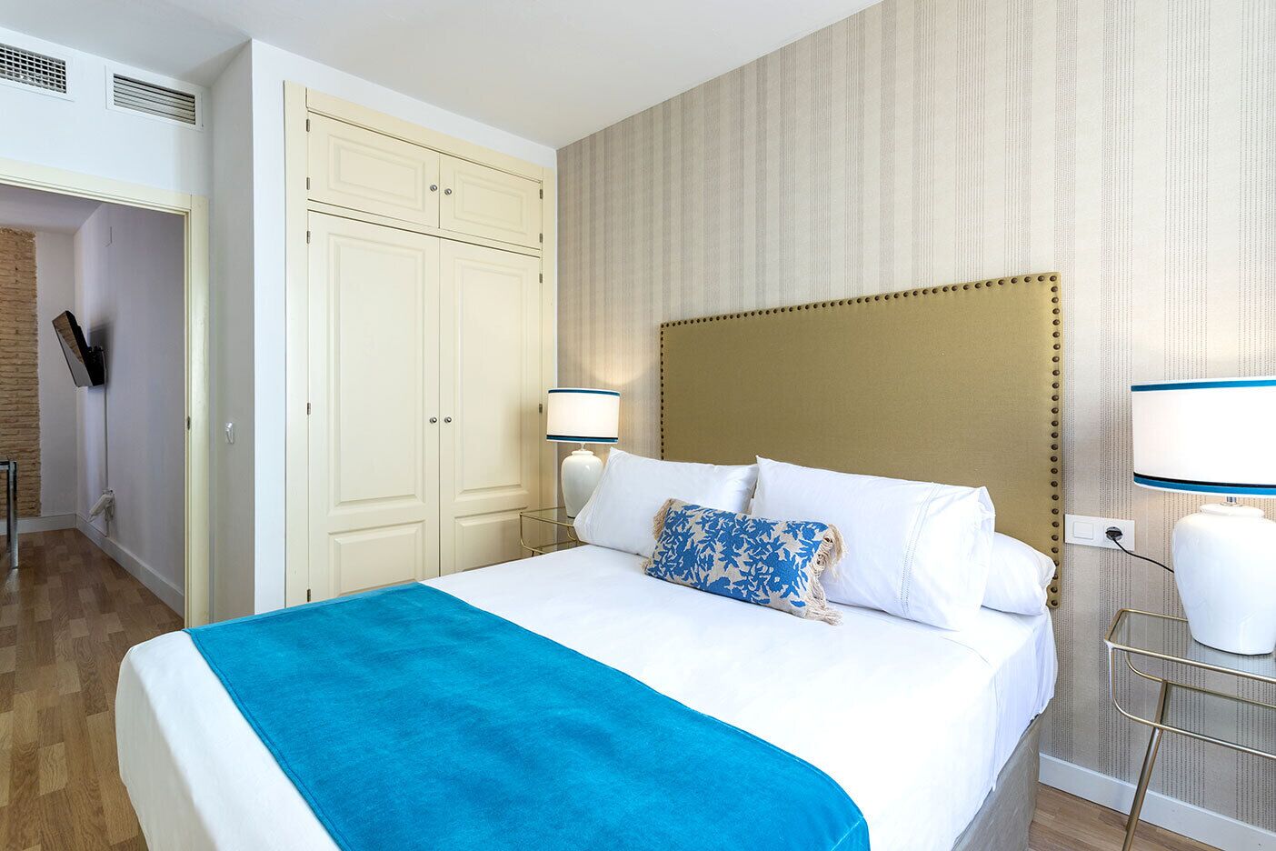 Une chambre d’hôtel équipée d’un lit, d’une armoire, d’un bureau et d’une télévision.