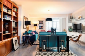 Un salon moderne comprenant un canapé, une table basse, une bibliothèque et un coin repas.