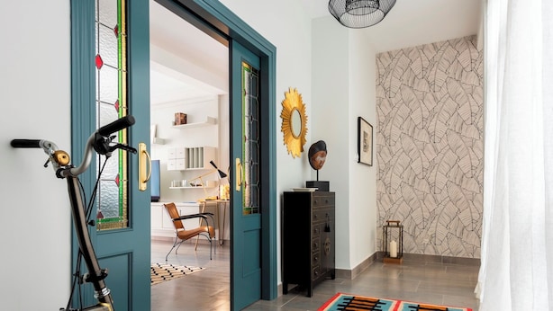 A hallway with a bicycle, a black cabinet, and a patterned wall. - Genteel Home Albareda (Seville)