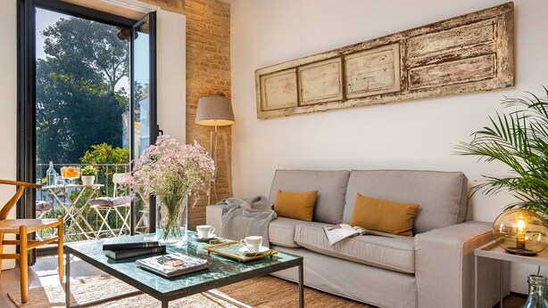 A living room with a sofa, coffee table, and a view of the outdoors. - Genteel Home Santa Teresa (Seville)