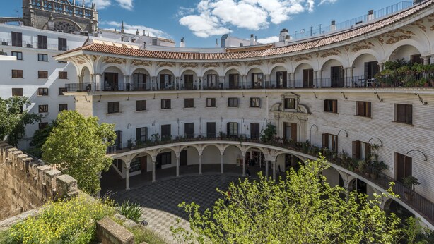 A courtyard with white buildings, arches, and a checkered floor. - Genteel Home Cabildo III (Seville)