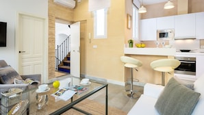 A modern apartment with a living area, kitchen, and a staircase. - Genteel Home Galera III (Seville)