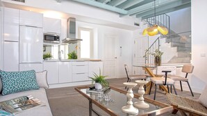 Una cucina moderna con pensili bianchi, un forno a microonde e una cappa in acciaio inossidabile.
