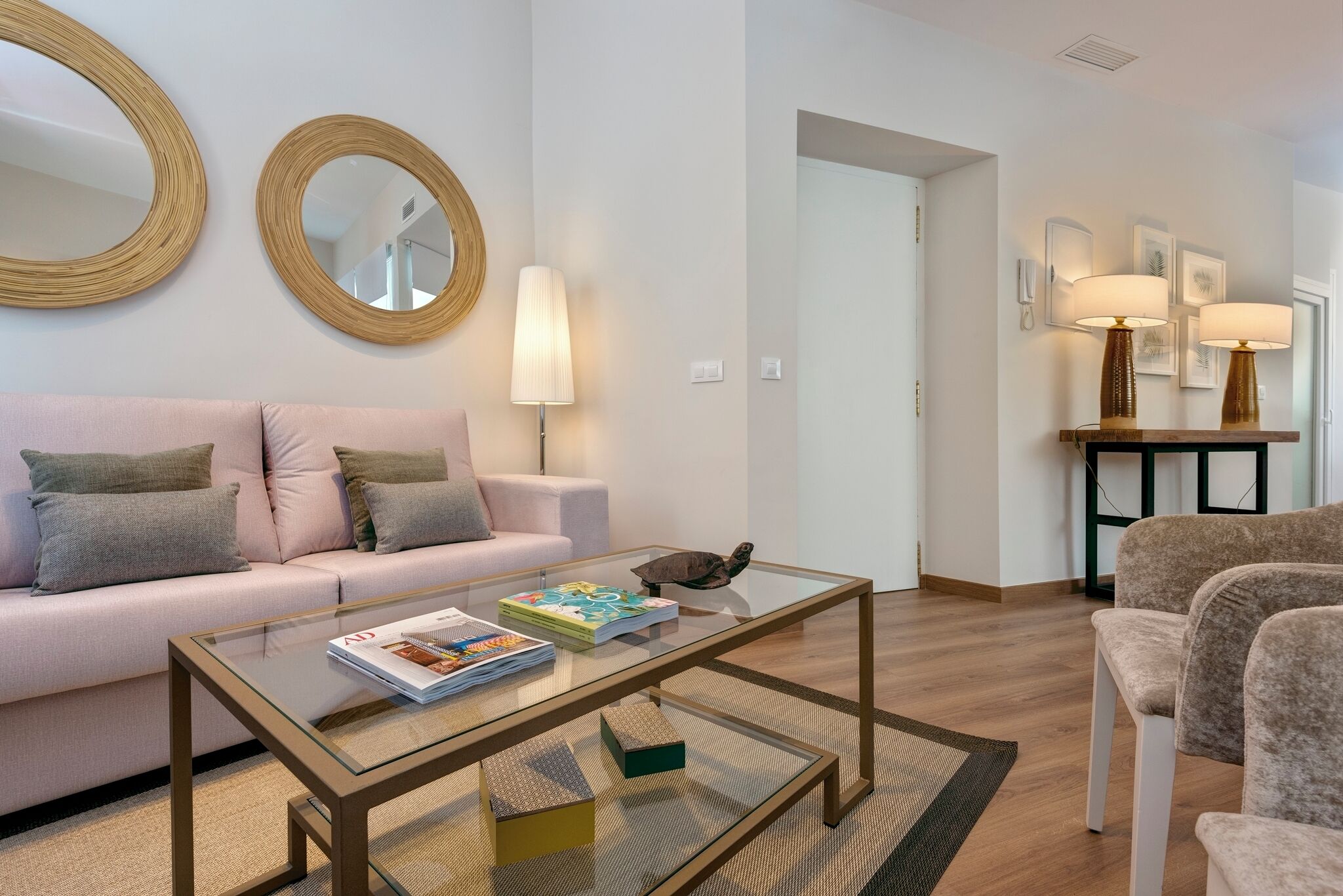 Ein modernes Wohnzimmer mit einem Glastisch, einem Sofa und einem Sessel.