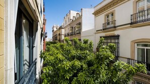 Rua estreita com edifícios de ambos os lados, com varandas e janelas.