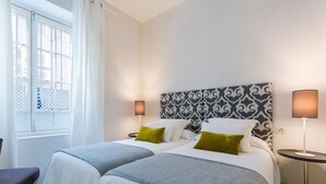 A hotel room with two beds, a window with a view, and bedside lamps. - Genteel Home Galera I (Seville)
