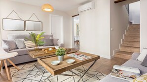 Un salon moderne avec un canapé, une table basse et un escalier.