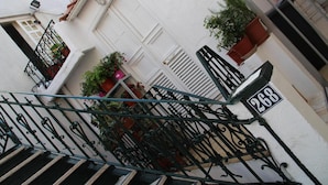 Un bâtiment blanc avec un escalier en métal noir menant à une porte portant le numéro 268.