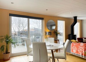Relax in this stylish living room with a sofa, dining table, and fireplace.