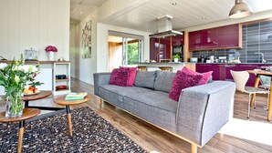 A modern living room with a grey sofa, a wooden coffee table, and a patterned rug. - Mulberry Lodge, Strawberryfield Park (Cheddar)