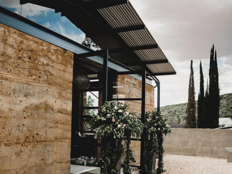 A modern building with a stone facade, a covered entrance, and a cobblestone courtyard.