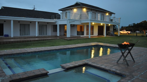 Ein zweistöckiges Haus mit Swimmingpool und Grill.