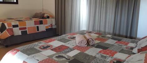 Een hotelkamer met twee bedden, elk met een ander quiltpatroon.