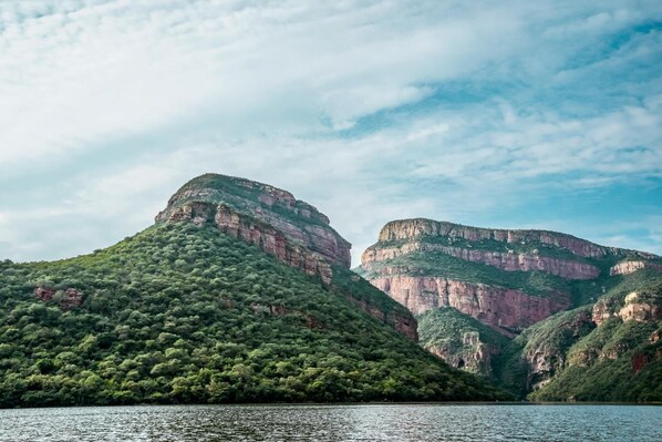 A mountainous landscape with a body of water in the foreground.