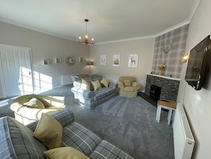 A living room with a fireplace, a sofa, a chair, and a coffee table.