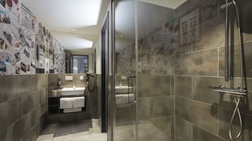 Une salle de bain moderne avec une douche à parois de verre, un lavabo avec un miroir et un porte-serviettes.