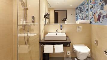 A modern bathroom with a glass shower enclosure, a white sink, and a toilet.