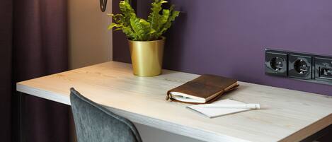 Un bureau avec une plante, un livre et un stylo.