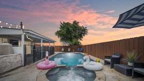 A backyard with a hot tub, inflatable pool toys, and outdoor furniture. - Family Retreat w/ Theater, Pool & Outdoor Dining (Chula Vista)