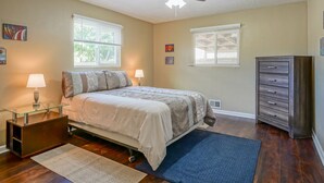 A bedroom with a bed, two bedside lamps, a ceiling fan, a dresser, and a window with blinds. - 4bd,2ba Remodeled North Valley Home w/ large yard (Los Ranchos De Albuquerque)