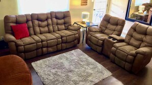 A living room with a sectional sofa, a small table with a lamp, and a rug on the floor. - 4bd,2ba Remodeled North Valley Home w/ large yard (Los Ranchos De Albuquerque)