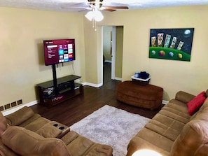 A living room with a flat-screen TV, a ceiling fan, and a painting on the wall. - 4bd,2ba Remodeled North Valley Home w/ large yard (Los Ranchos De Albuquerque)