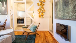 Una sala moderna con chimenea, un comedor con mesa y sillas, una cocina con horno y un adorno mural.
