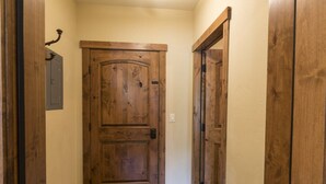 A wooden door in a hallway with a stone-tiled floor. - Hotel Style Room Near Slopes (Whitefish)
