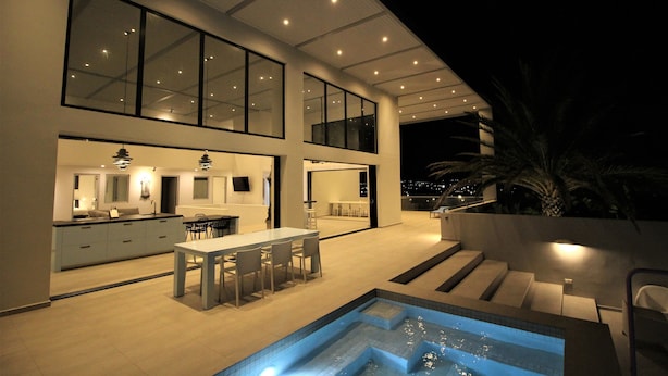 Una casa moderna con una cocina amplia, comedor y piscina.