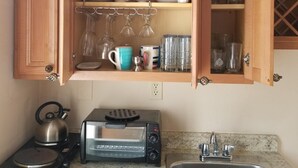 Eine Küche mit Holzschränken, einem Toaster, einem Wasserkocher und einer Spüle.