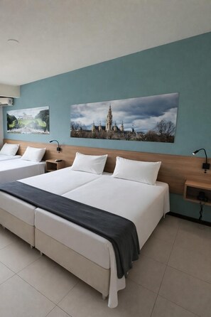 A hotel room with two beds, a large window, and artwork on the wall. - Rede Andrade Criciúma (Criciuma)