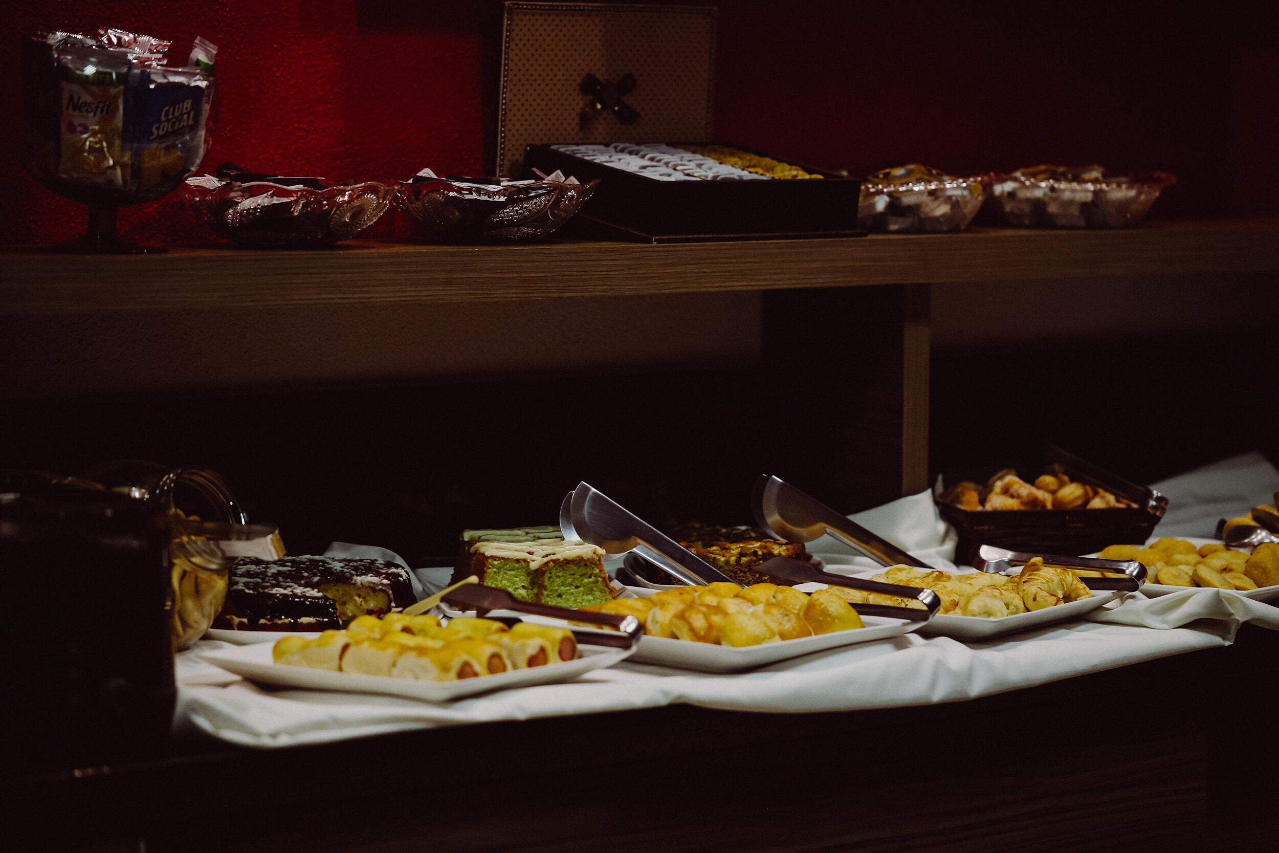 A buffet table with various food items and serving utensils.