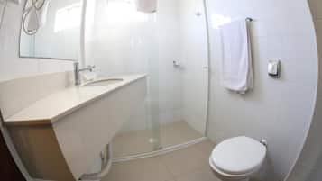 A modern bathroom with a glass-enclosed shower, a white sink, and a toilet.