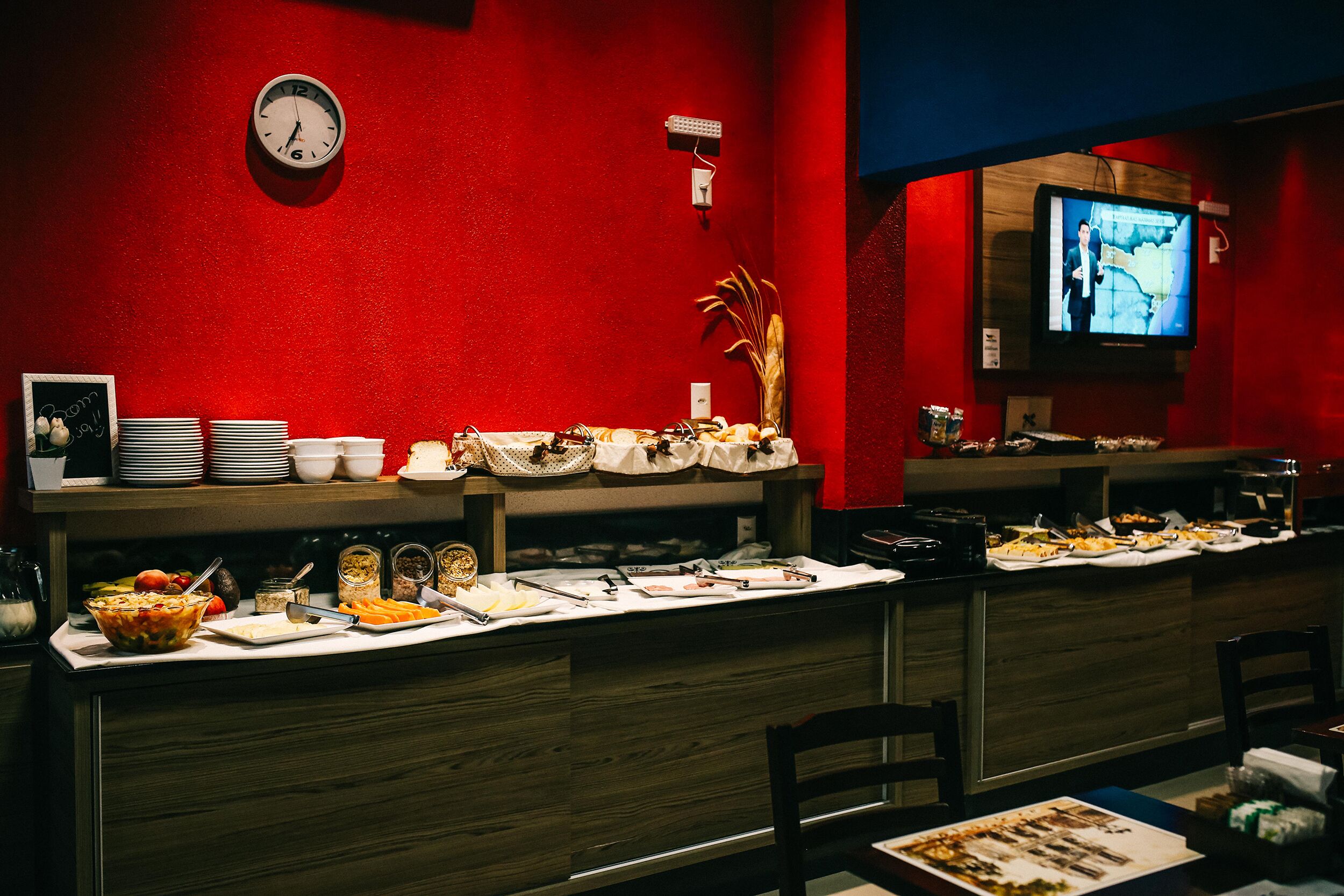 A buffet setup with various food items and a clock on the wall.