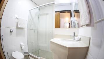 Un baño moderno con ducha acristalada, lavabo blanco y retrete.