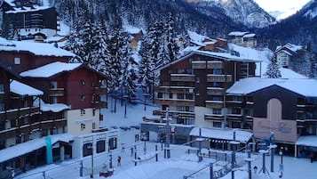 Un centro de esquí cubierto de nieve con varios edificios, incluyendo alojamientos y una zona de teleférico.