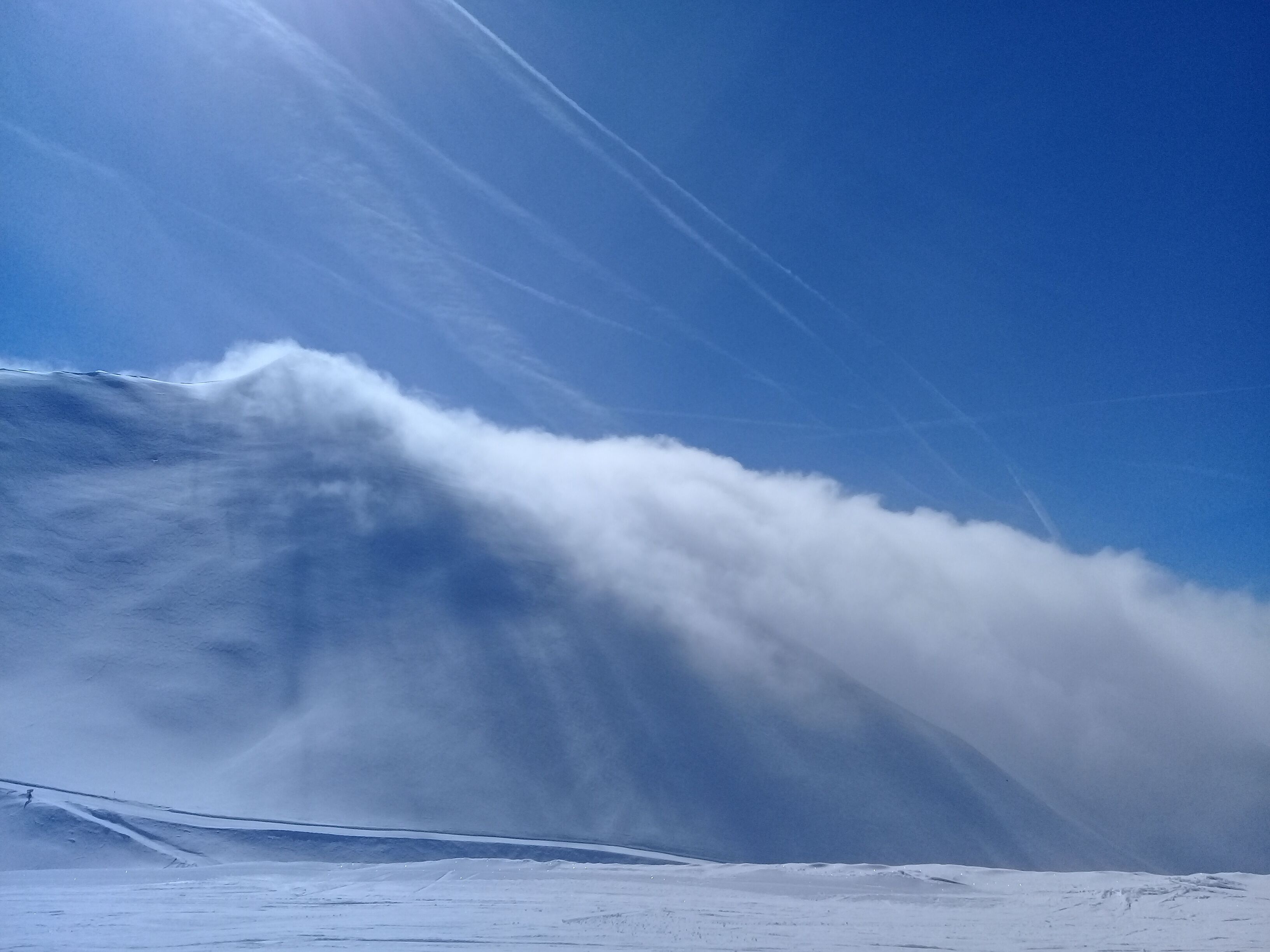 Eine verschneite Berglandschaft mit blauem Himmel.