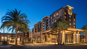 A multi-story hotel with a modern architectural design, featuring a prominent entrance with a covered walkway and palm trees in the foreground. - Brownwood Hotel & Spa (Wildwood)