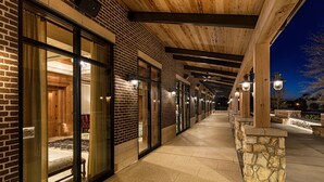 A corridor with glass doors leading to a room, stone walls, and wooden beams. - Brownwood Hotel & Spa (Wildwood)
