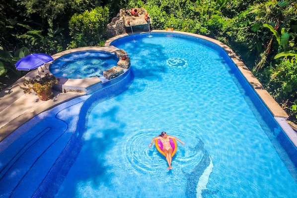 Una piscina al aire libre, tumbonas