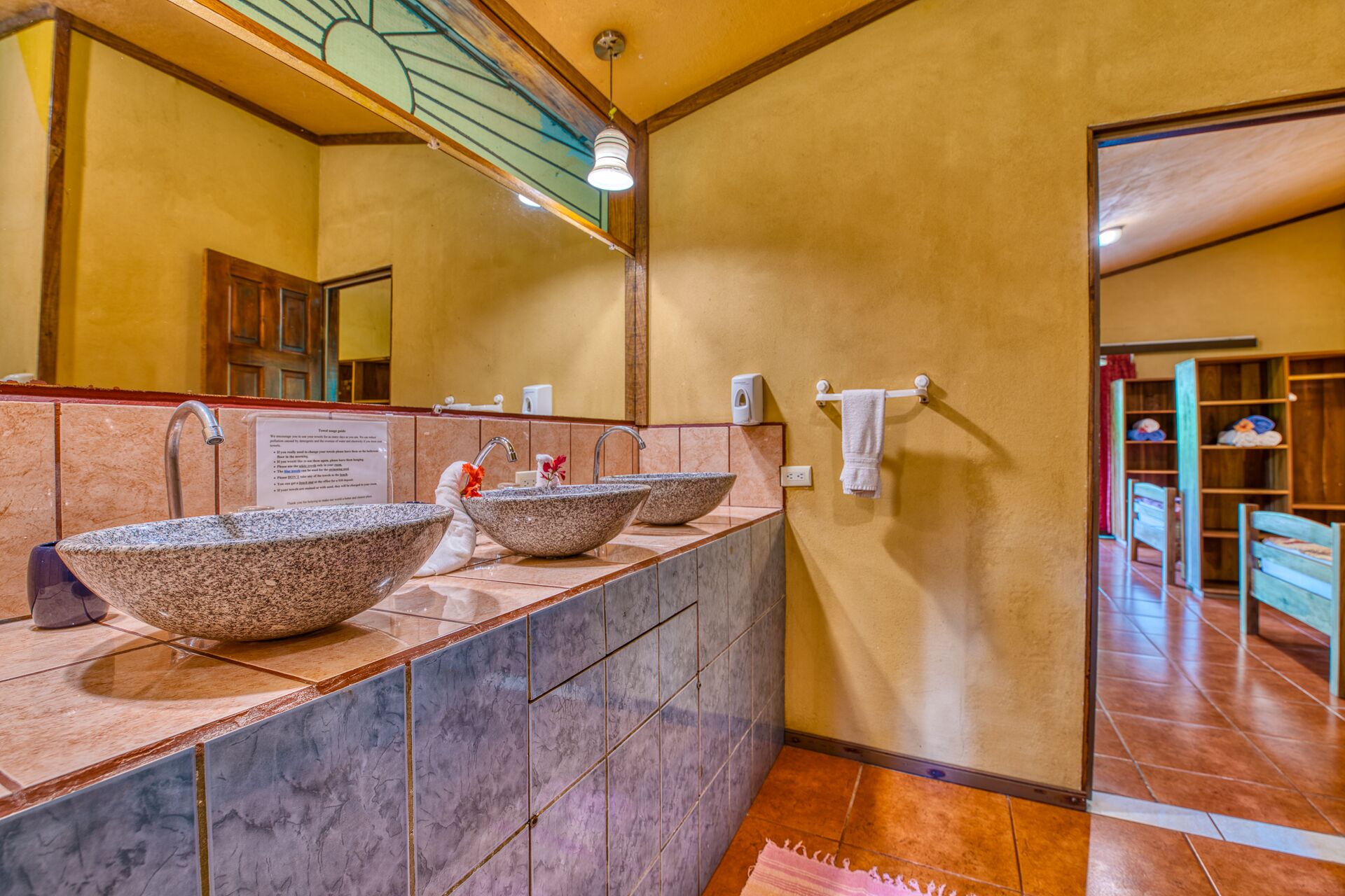 A bathroom with a large marble sink, a mirror, and a towel rack.