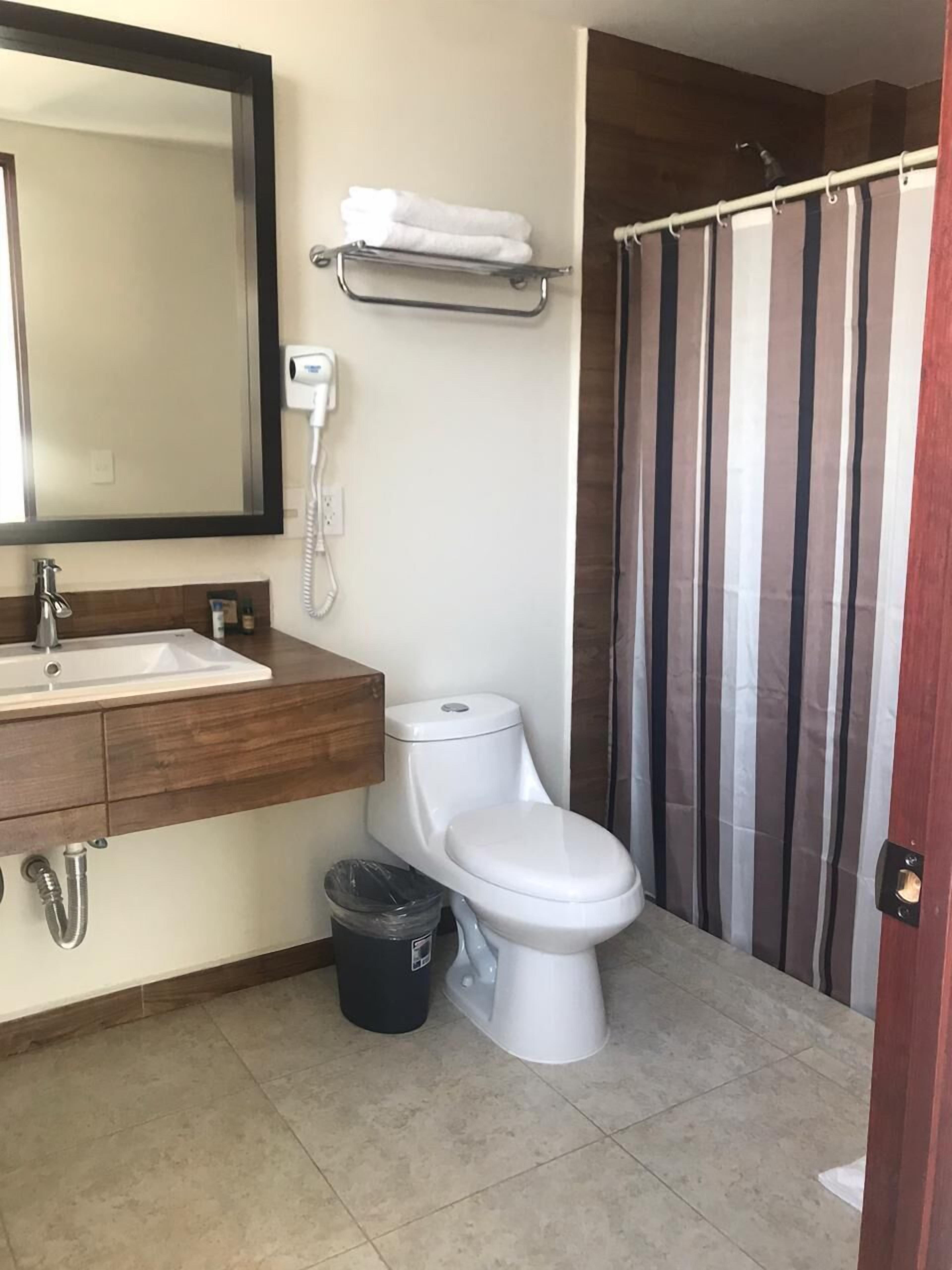 deluxe room, multiple beds | bathroom | hair dryer, towels, soap, shampoo