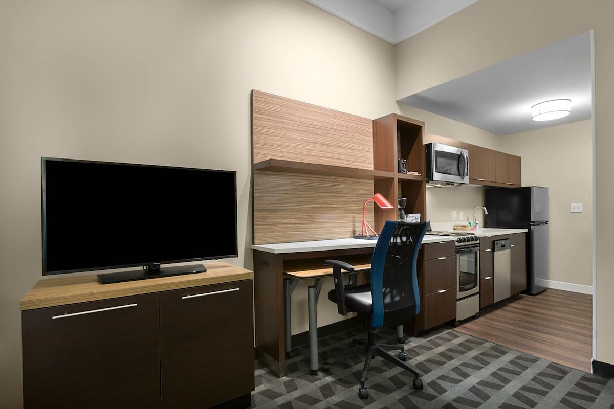 A compact kitchen with a microwave, oven, and refrigerator.