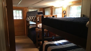 A bunk bed room with a wooden ladder, a window with blinds, and a mirror on the wall. - Cute, rustic cabin in Side Lake, No WiFi (Side Lake)